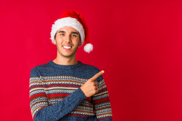 Young man on christmas day smiling and raising thumb up