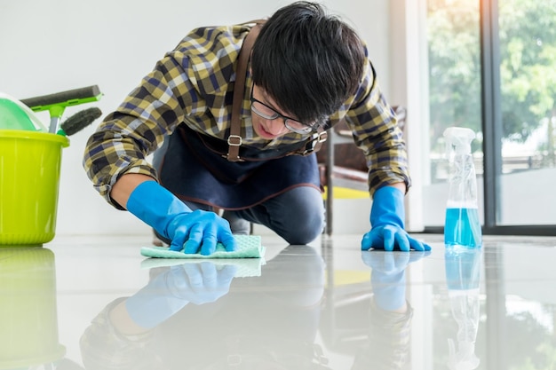 Young man cleaning floor at home