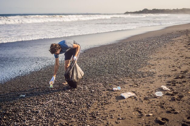 Young man cleaning up the beach natural education of children