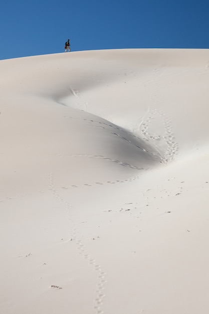 Young man climbing a sand dune