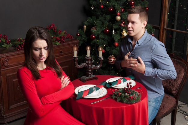 Young man confesses his love for dissatisfied beautiful woman, love couple at luxury restaurant.