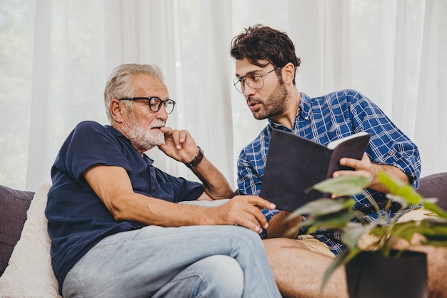 young man consulting business project or education lecture content in text book with retired senior elder at home