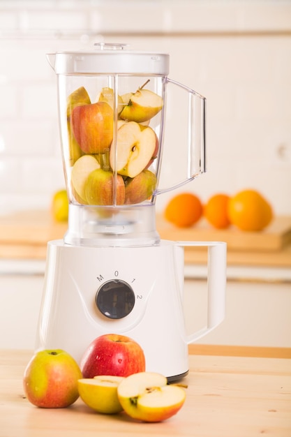 Young man cooking apple smoothie in blender