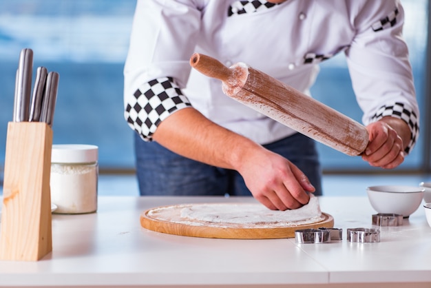 Young man cooking cookies in kitchen