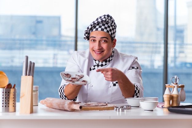 Young man cooking cookies in kitchen