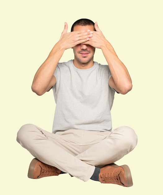 Young man covering his eyes with his hands