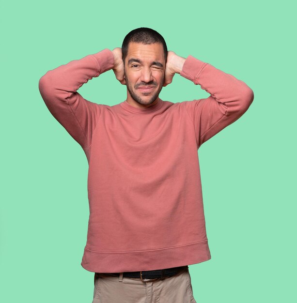 Young man covering his eyes with his hands