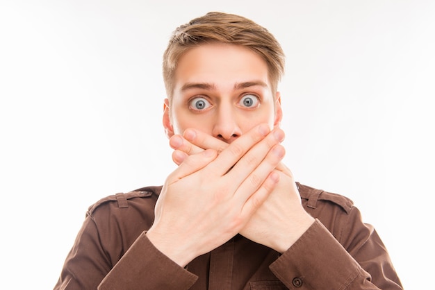 Young man covering his mouth with hands