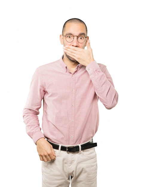 Young man covering his mouth with his hands