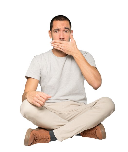 Young man covering his mouth with his hands