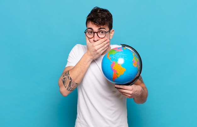 Young man covering mouth with hands with a shocked