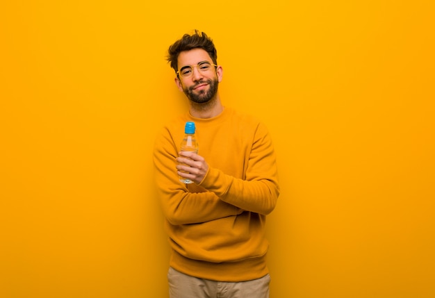 Young man crossing arms, smiling and relaxed