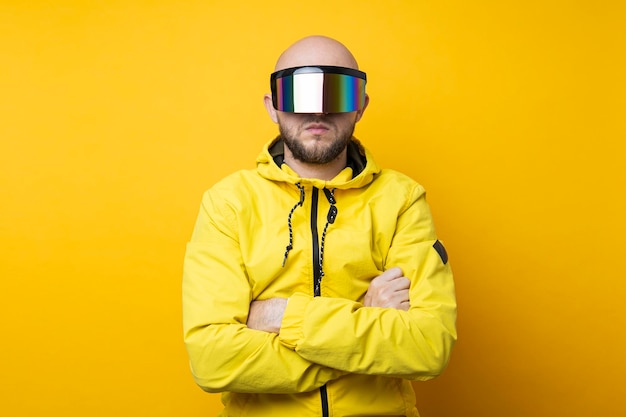 Молодой человек в киберпанк-очках в желтой куртке на желтом фоне