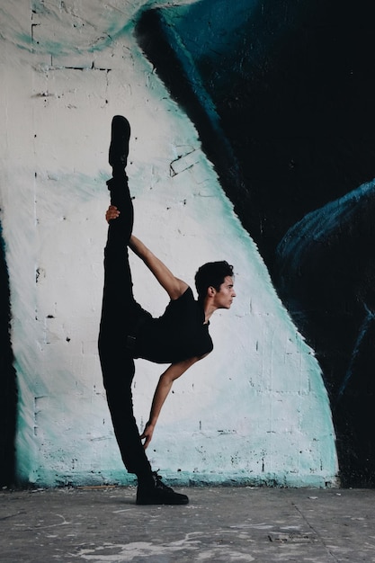 young man dancing against wall