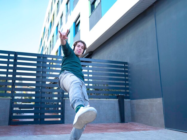 Foto giovane che balla vicino a una porta di metallo in città