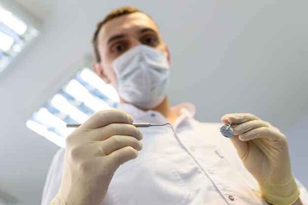 보호 장갑과 마스크를 쓴 젊은 남자 치과의사