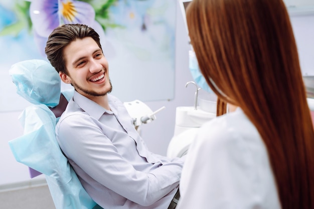 Young man at the dentist's chair during a dental procedure Overview of dental caries prevention