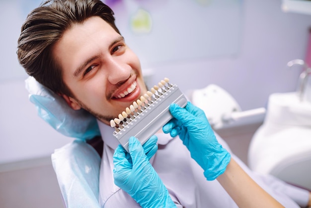 Young man at the dentist's chair during a dental procedure Overview of dental caries prevention