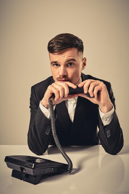 Young man dials the phone number while sitting in the office