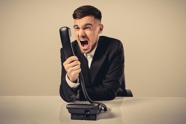 Young man dials the phone number while sitting in the office