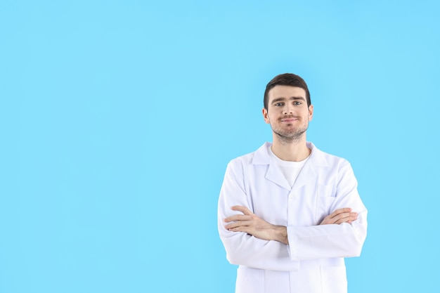 Young man doctor on blue background, healthcare and medicine