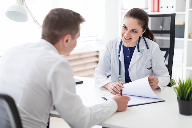 The young man at the doctor's office signs the documents.