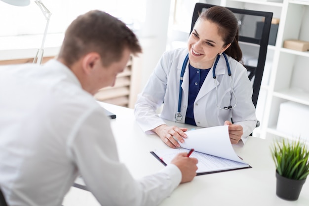 The young man at the doctor's office signs the documents.