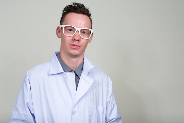 young man doctor with eyeglasses against white space