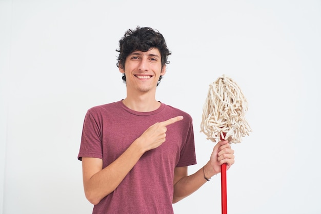 Young man does household chores shows mop
