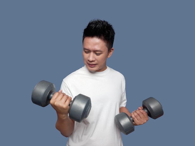 Young man doing arm exercises using dumbbells isolated on plain background