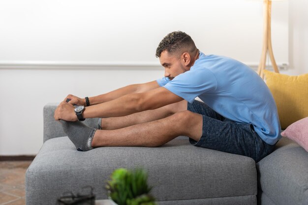 Young man doing back stretching exercises