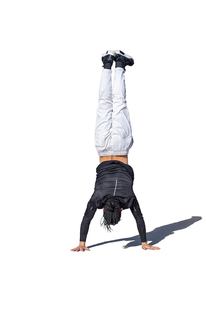 Young man doing break dance stunts with shade and white background