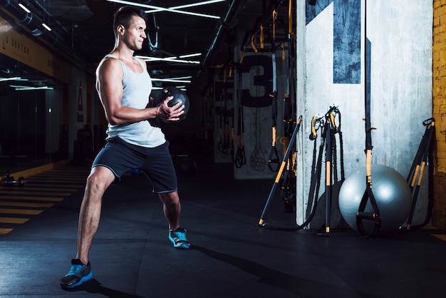 Photo young man doing exercise with medicine ball