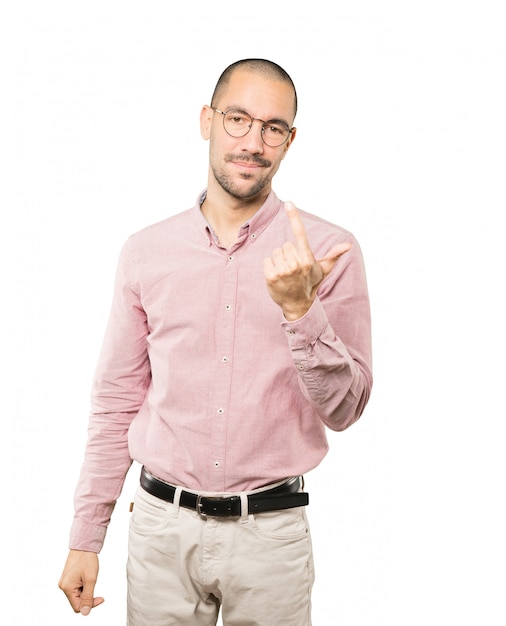 Young man doing a gesture of come here