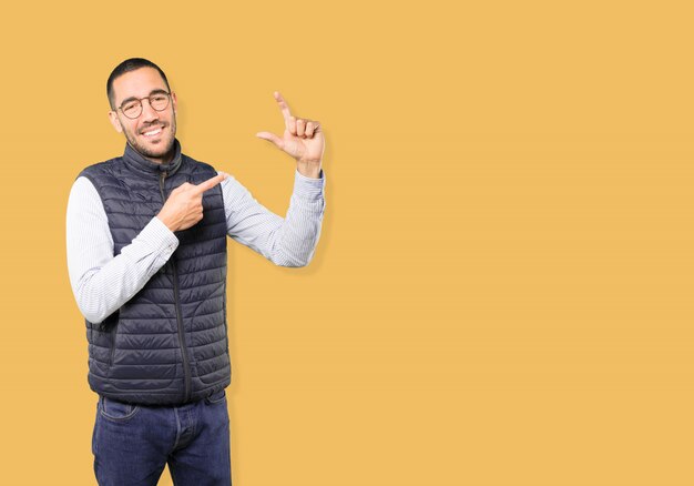 Young man doing a gesture of small size with his hand