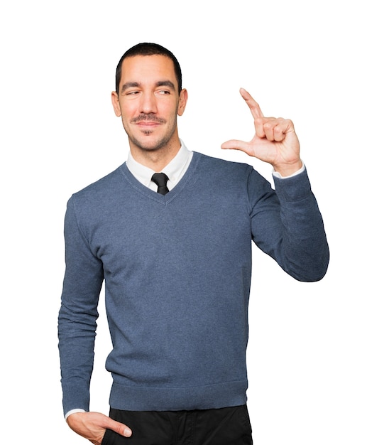 Young man doing a gesture of small size with his hand