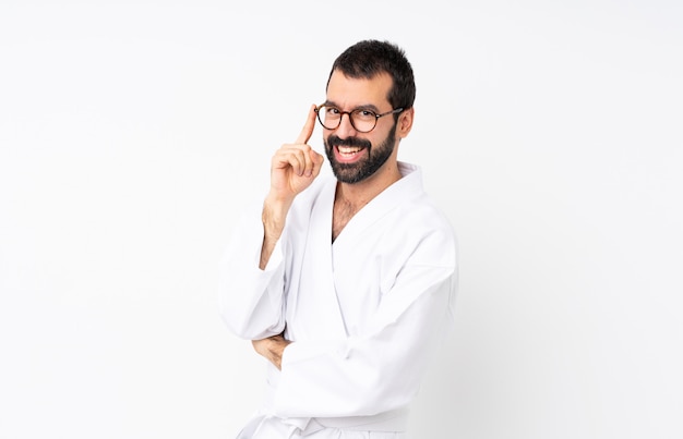 Young man doing karate over isolated  with glasses and smiling