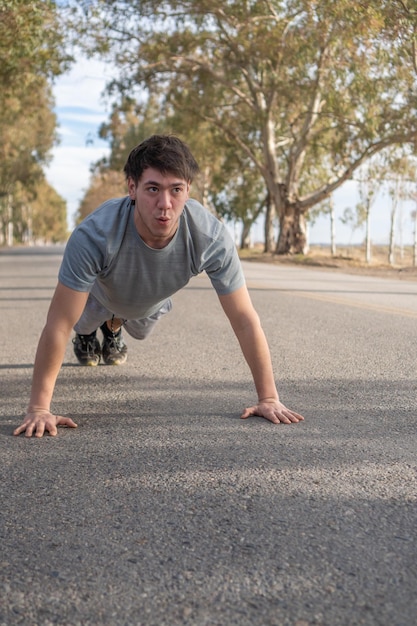 Young man doing pushups outdoors