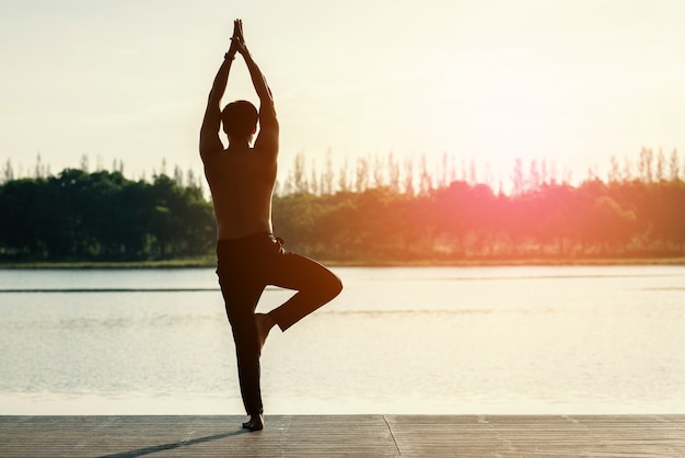 Photo young man doing yoga in morning park