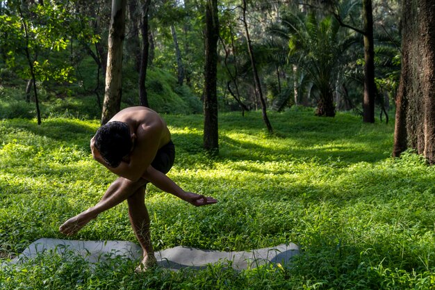 Young man doing yoga or reiki in the forest very green vegetation in mexico guadalajara bosque colomos hispanic