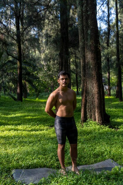 Young man doing yoga or reiki in the forest very green vegetation in mexico guadalajara bosque colomos hispanic