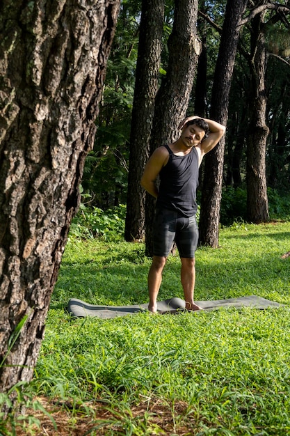 Young man doing yoga or reiki in the forest very green vegetation in mexico guadalajara bosque colomos hispanic