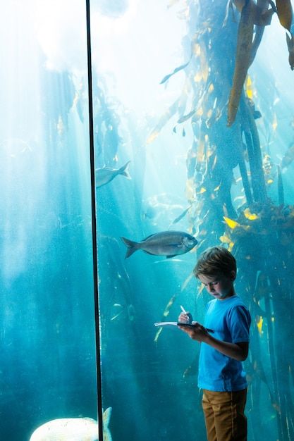 Young man drawing a fish in a tank 