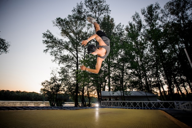 젊은 남자는 공원에서 캐주얼 의류 trampolining 입고