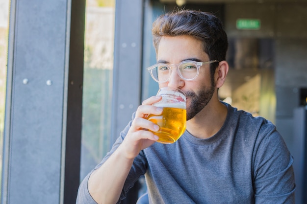 若い男がビールを飲む