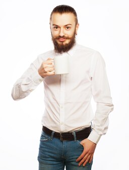 Il giovane che beve una tazza di caffè o di tè ha isolato il fondo bianco