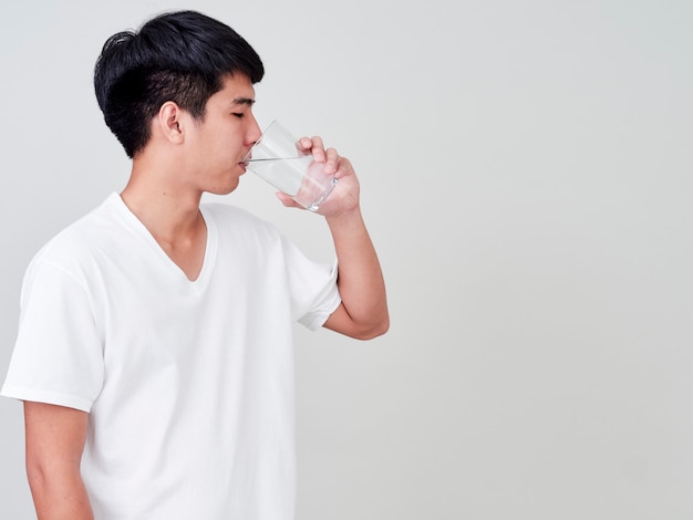 Young man drinking water of glass.