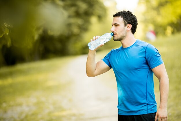 Giovane uomo che beve acqua