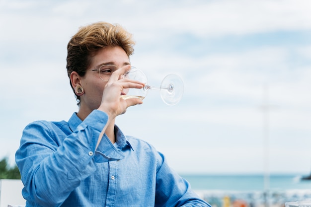 Young man drinking wine sitting on a restaurant