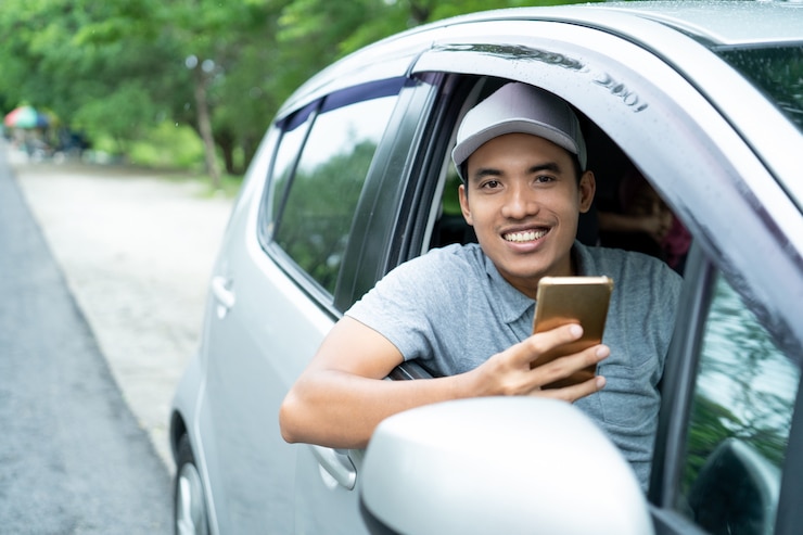 https://img.freepik.com/premium-photo/young-man-driver-use-smartphone-look-camera_8595-2909.jpg?w=740